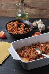 The process of preparing Italian rustic lasagna. Stages of cooking. Ingredients and place for signature.