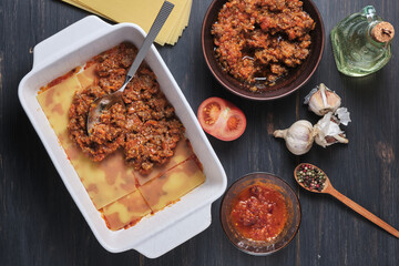The process of preparing Italian rustic lasagna. Stages of cooking. Ingredients and place for signature. Top view.