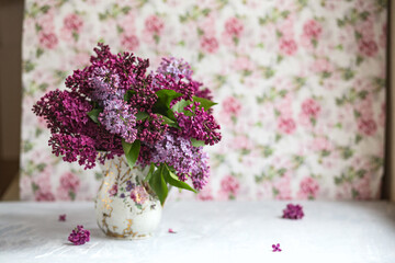 Bouquet of violet lilac in a vase. Still life with blooming branches of lilac in vases.