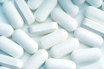 white pills spilled on white background