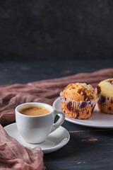 Espresso and muffins with berries and chocolate on a plate. Coffee and dessert for breakfast.