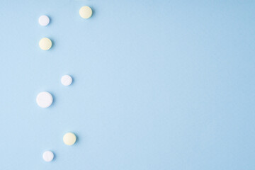 Pills on blue background. Copy space, top view