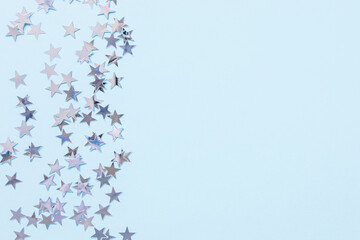 Christmas festive abstract backround with silver foil confetti stars on blue. Birthday party, New...