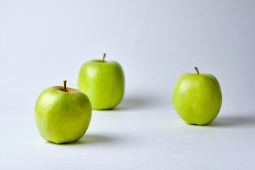Three large green apples close-up on a white background.