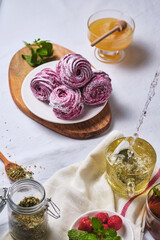 Herbal tea with honey and mint and homemade berry zephyr. Delicious and healthy breakfast on a linen tablecloth. Strawberry-currant marshmallows.