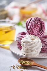 Herbal tea with honey and mint and homemade berry zephyr. Delicious and healthy breakfast on a linen tablecloth. Strawberry-currant marshmallows.