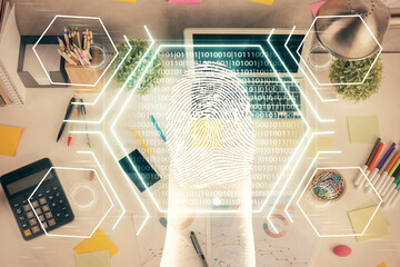 Finger print over computer on the desktop background. Top view. Double exposure. Concept of securitization.