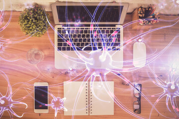 Neuron hologram drawings over computer on the desktop background. Top view. Multi exposure. Concept of education.