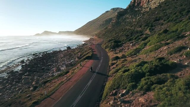  Motorcyclists traveling on road along coastline