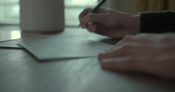  Young woman writing letter at desk