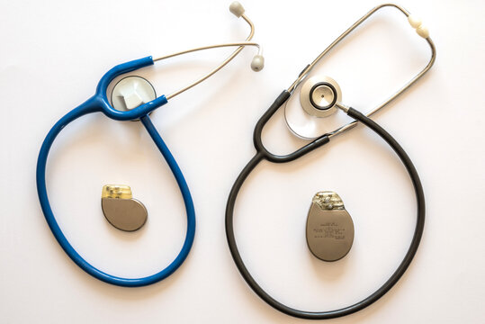 two rounded stethoscopes with a pacemaker battery in the center with white background