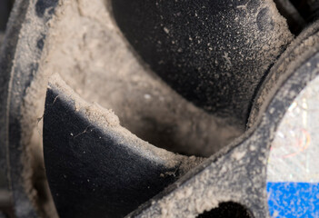 Part of a dirty CPU fan. Shallow depth of field, focus on top of blade. Dirt below completely clogs...