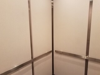 interior of elevator with white walls and metal bars