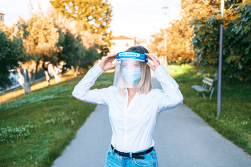 Business female in face shield isolation transparent mask on urban background. Health protection...