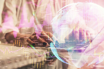 Double exposure of woman hands typing on computer and forex chart hologram drawing. Stock market...