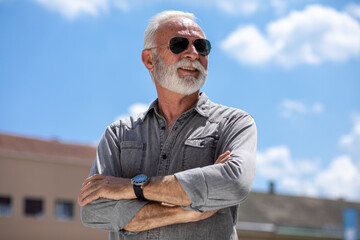 Old rich man with sun glasses and beard on street portrait