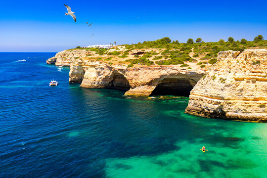 Corredoura Beach, sighted viewpoint on the trail of the Seven Suspended Valleys (Sete Vales Suspensos). Praia da Corredoura with flying seagulls near Benagil village, Algarve, Portugal.