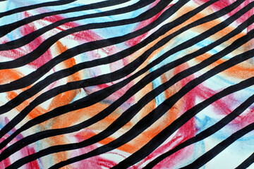 Striped fabric texture. Black waves on a multicolored background. Orange, pink, and blue spots and black lines.
