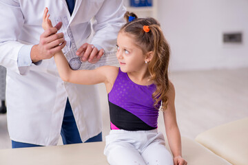 Small girl visiting young male doctor