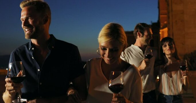 MS TS SELECTIVE FOCUS Four young people at party at terrace at night / Cagliari, Italy