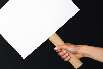 activist with an empty poster. protest banner on black background
