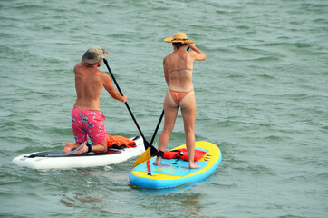 Man and a woman paddle boarding on biscayne bay