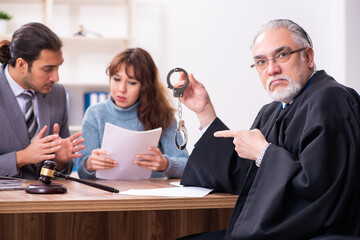 Young woman in courthouse with judge and lawyer