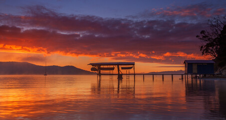 Beautiful winter's sunrise over Coningham Boat Shed.North West Bay.South East Coast of Tasmania,Australia.