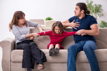 Young couple and their daughter in family conflict concept