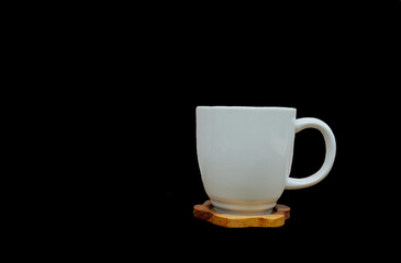 A white cup of coffee on a black background