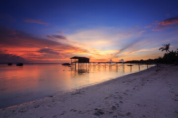 Fototapeta premium Amazing beautiful sunset with silhouette wooden jetty and coconut tree
