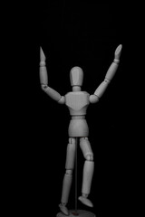 wooden mannequin standing on black background with lively man posture