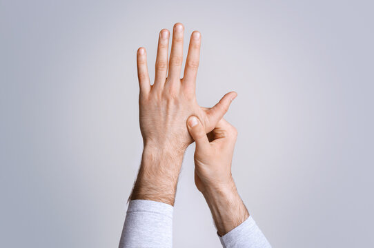 Arthritis And Finger Pain. Man Press To Sore Spot, Studio Shot