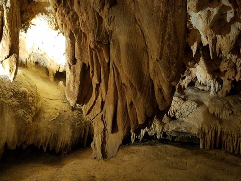 brown stalactites and stalagmites in cave or cavern
