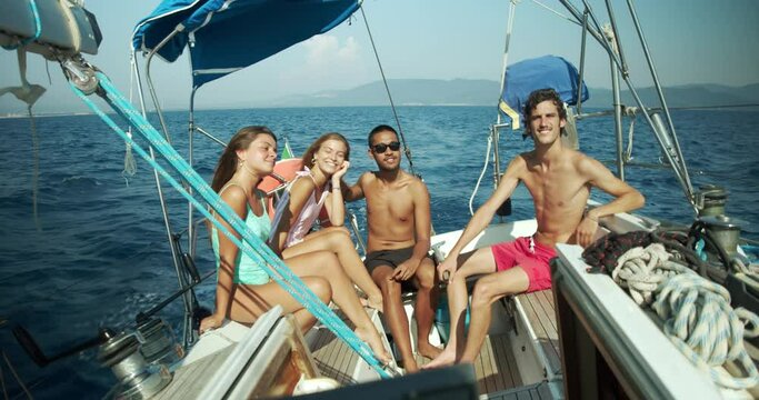 Group of young friends enjoying trip on a sailboat in the Ligurian Sea.
