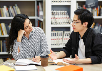 Multicultural couple sharing ideas in public library