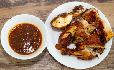 Thai style grilled chicken with chili sauce on the white dish 
