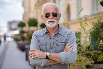 Old rich man with sun glasses and beard on street portrait