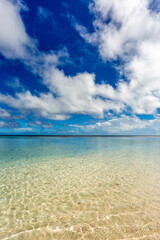 Blue sky and white clouds reflected in clear ocean