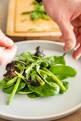 man making fresh summer salad on kitchen