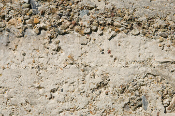 The texture of the wall is cement mixed with small stones.