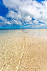 Fototapeta na wymiar Waves, water ripples, white sandy beach and blue sky