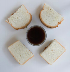 four slices of bread with black coffee for breakfast in accompany to stay at home 