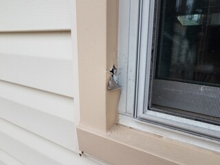 hole in damaged metal frame of window on house