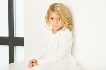 Naklejka premium Little girl near a large panoramic window in a large studio.