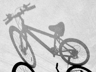 Fototapeta na wymiar The light and shadow of the bicycle on the concrete road surface.