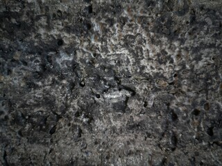 The rough surface of a black concrete wall.