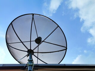 Television dish antenna on the roof and background is the blue sky and cloud.