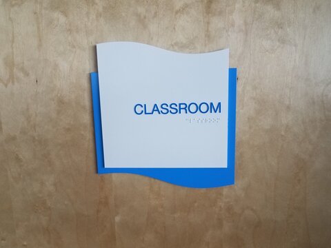 blue classroom sign on door with braille