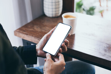 cell phone mockup image blank white screen.woman hand holding texting using mobile on desk at coffee shop.background empty space for advertise.work people contact marketing business,technology